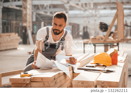 Project of wooden building. Industrial worker in warehouse Project of wooden building. Industrial worker in warehouse 132262211