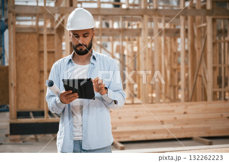 Digital tablet is in hands. Industrial worker in wooden warehouse 132262223