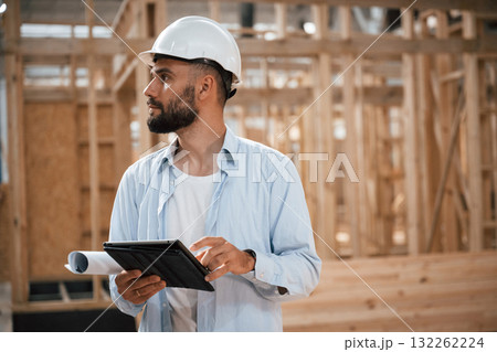 Digital tablet is in hands. Industrial worker in wooden warehouse Digital tablet is in hands. Industrial worker in wooden warehouse 132262224