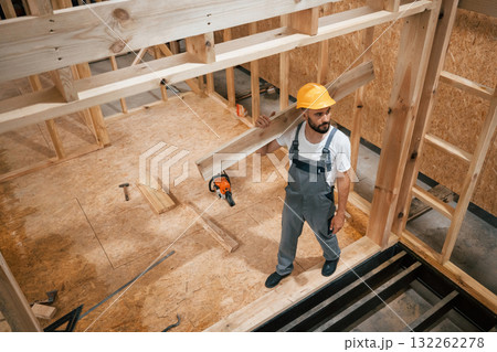 In yellow hardhat. Industrial worker in wooden warehouse In yellow hardhat. Industrial worker in wooden warehouse 132262278