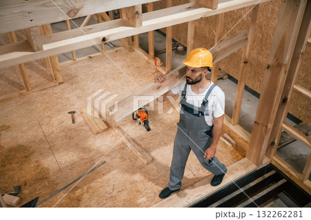 Project of wooden building. Industrial worker in warehouse 132262281
