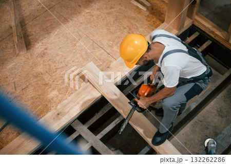 Saw in hands. Industrial worker in wooden warehouse 132262286
