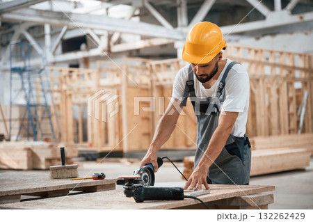 By the table. Industrial worker in wooden warehouse By the table. Industrial worker in wooden warehouse 132262429