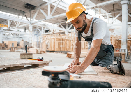 By the table. Industrial worker in wooden warehouse 132262431