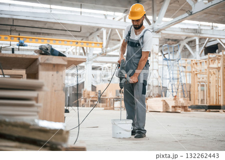 Big drill. Industrial worker in wooden warehouse Big drill. Industrial worker in wooden warehouse 132262443