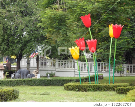 Red and Yellow Tulip Sculptures in a Park with Elephant Statues in the Background 132262707
