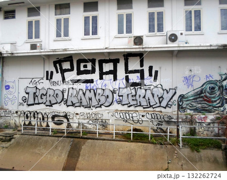 Graffiti Wall with Bold Text and Symbols on an Urban Street 132262724