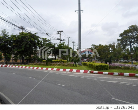 Roadside Scene with Red and White Barriers and Lush Gardens in the Background 132263043