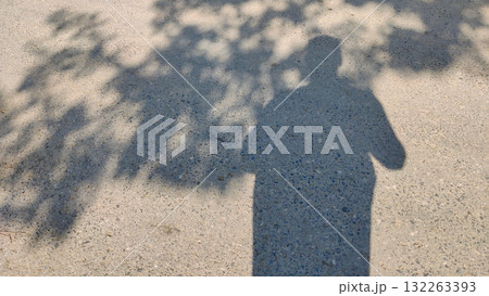 Shadow of man and tree on ground in daylight symbolizing human connection with nature solitude and peaceful reflection Shadow of man and tree on ground in daylight symbolizing human connection with nature solitude and peaceful reflection 132263393