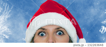 oung woman wearing a Santa hat on frozen blue background. 132263648