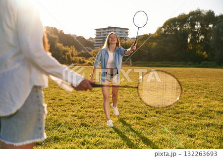 Two women are having fun, with badminton rackets, on the field 132263693