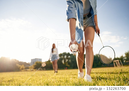 Two women are having fun, with badminton rackets, on the field 132263700