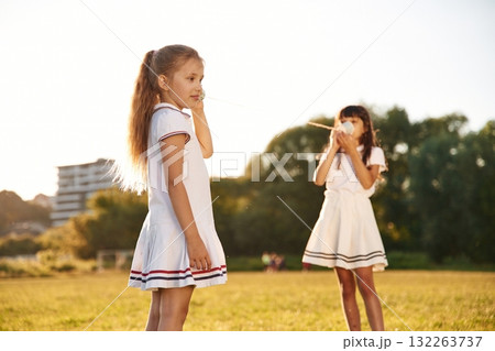 Fun, with tin can phone. Happy kids are on the summer field 132263737