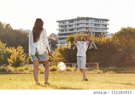 Conception of sports and hobby. Man with woman are playing badminton on the field 132263935