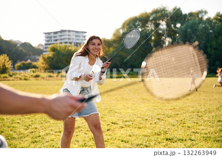 On the summer field. Man with woman are playing badminton On the summer field. Man with woman are playing badminton 132263949