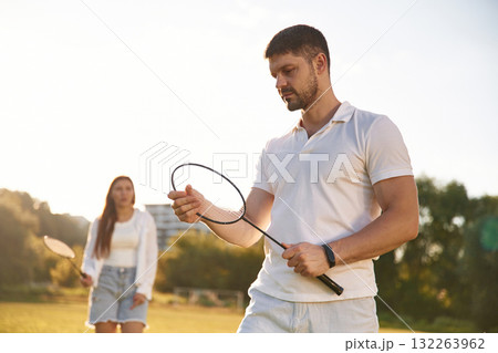 Man with woman are playing badminton on the field Man with woman are playing badminton on the field 132263962