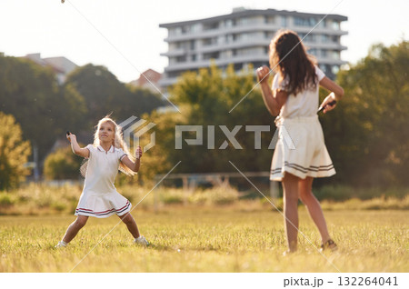 Game of badminton. Happy kids are on the summer field 132264041