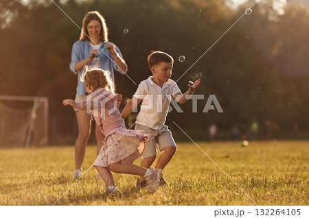 Woman with kids is on the summer field Woman with kids is on the summer field 132264105