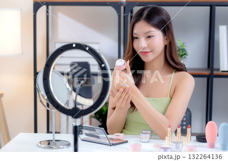 Young asian woman presenting and review cosmetic product with on social media. Young asian woman presenting and review cosmetic product with on social media. 132264136