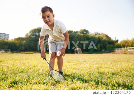 Happy little boy is with two tennis rackets on the summer field 132264170