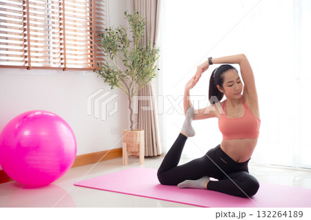 Young asian woman practicing Yoga with stretching muscle back on yoga mat in living room. Young asian woman practicing Yoga with stretching muscle back on yoga mat in living room. 132264189