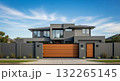 A gray private house of two floors hidden behind a fence with automatic sliding brown gates 132265145