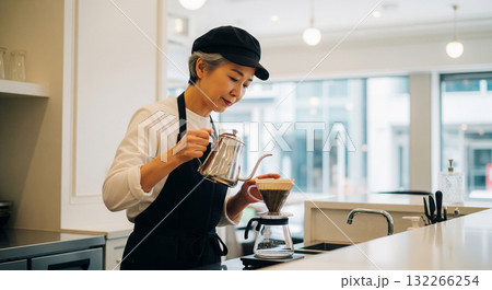 シニア世代のカフェ店員がコーヒーを淹れている 132266254