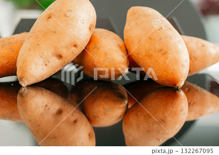 Several sweet potatoes on glossy black table clean healthy food concept and natural light 132267095