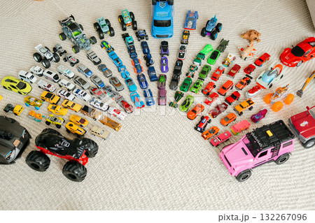 Top-down view of colorful toy cars arranged in an ordered semicircle on carpet collector display and playful pattern 132267096