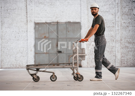 Pallet with nothing on it. Male worker is in the empty warehouse 132267340