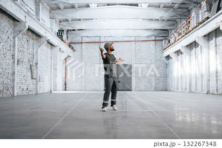 Huge area. Male worker is in the empty warehouse Huge area. Male worker is in the empty warehouse 132267348