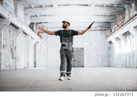 Painted in white. Male worker is in the empty warehouse 132267371
