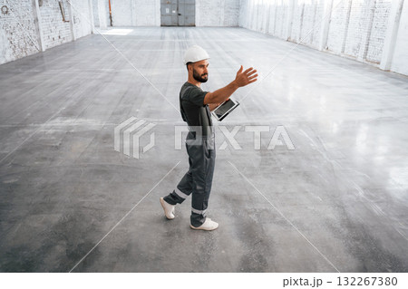 Showing the area by the hands. Male worker is in the empty warehouse 132267380