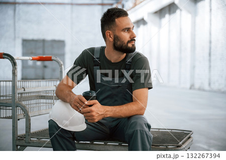 Pallet with nothing on it. Male worker is in the empty warehouse Pallet with nothing on it. Male worker is in the empty warehouse 132267394