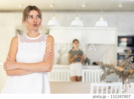 Serious woman is standing in kitchen and thinking about something Serious woman is standing in kitchen and thinking about something 132267807