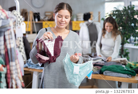 Female shopper selects panties in fashionable clothing boutique. 132267813