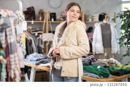 Preparing for fall and winter - girl try fur coat in clothes store Preparing for fall and winter - girl try fur coat in clothes store 132267850