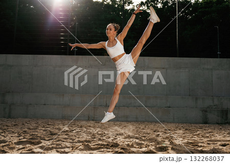 Up in the air, jumping. Young skinny fitness woman is outdoors 132268037