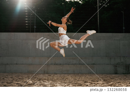 Up in the air, jumping. Young skinny fitness woman is outdoors 132268038