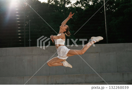 Up in the air, jumping. Young skinny fitness woman is outdoors 132268039