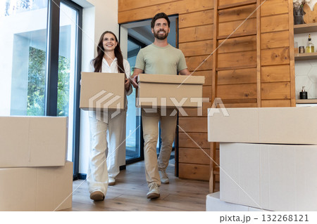 Man and woman carrying boxes into a new accommodation and feeling excited 132268121