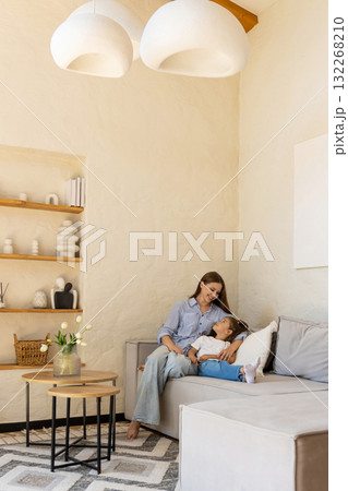 Smiling daughter leaning on her mother while sharing love and happiness Smiling daughter leaning on her mother while sharing love and happiness 132268210