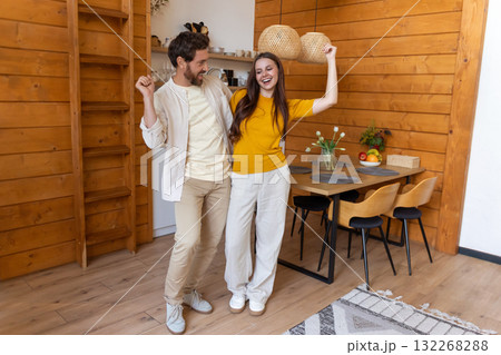 Cute couple feeling excited and joyful while dancing in the kitchen 132268288
