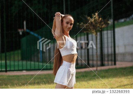 Posing, relaxed. Young skinny fitness woman is outdoors Posing, relaxed. Young skinny fitness woman is outdoors 132268393