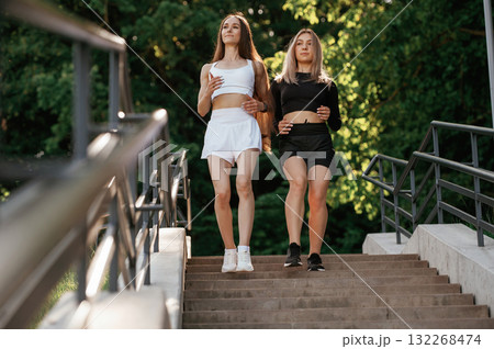 Walking the stairs. Two sportive women are outdoors together 132268474