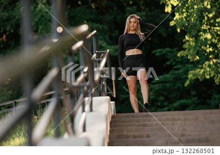 On the bridge with stairs. Beautiful fitness woman in sport clothes is outdoors On the bridge with stairs. Beautiful fitness woman in sport clothes is outdoors 132268501