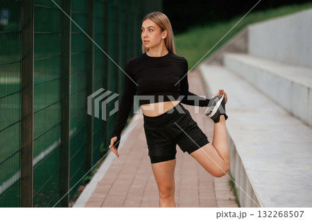 Warm up exercises. Beautiful fitness woman in sport clothes is outdoors Warm up exercises. Beautiful fitness woman in sport clothes is outdoors 132268507