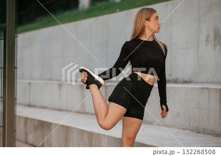Warm up exercises. Beautiful fitness woman in sport clothes is outdoors Warm up exercises. Beautiful fitness woman in sport clothes is outdoors 132268508