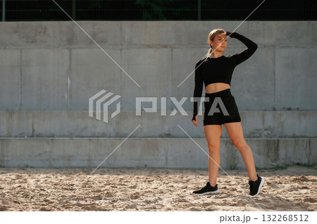 Full height photo. Beautiful fitness woman in sport clothes is outdoors 132268512