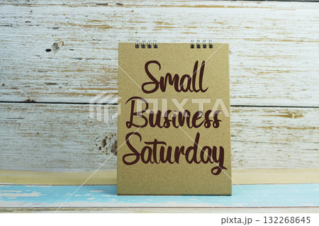 A brown card with the text "Small Business Saturday" against a rustic white wooden background A brown card with the text "Small Business Saturday" against a rustic white wooden background 132268645
